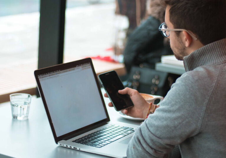 Businessman on his laptop and using his phone at a restaurant.